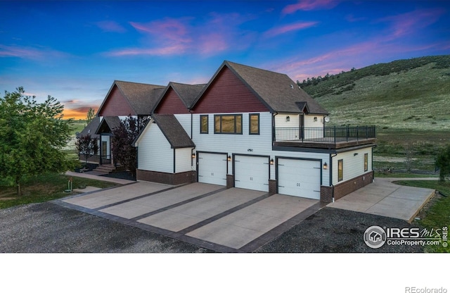 6950 W County Road 18, Loveland, CO 80537 - view of front of property featuring an attached garage, driveway, brick siding, and a balcony