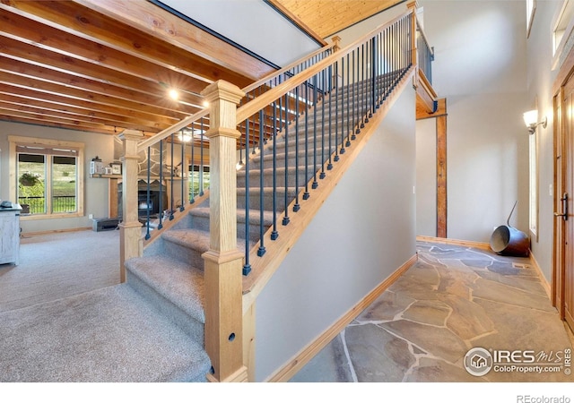 6950 W County Road 18, Loveland, CO 80537 - stairs with baseboards, stone flooring, carpet, and a fireplace with raised hearth