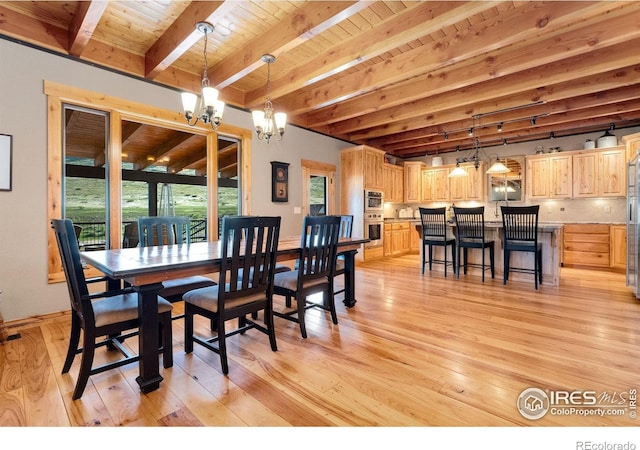 6950 W County Road 18, Loveland, CO 80537 - dining space with beamed ceiling, a chandelier, light wood finished floors, wood ceiling, and baseboards