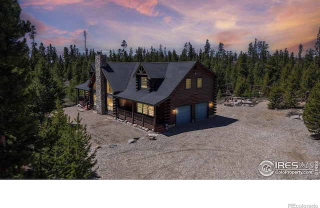 315 County Road 4454, Grand Lake, CO 80447 - log-style house featuring log siding, driveway, covered porch, a chimney, and a garage
