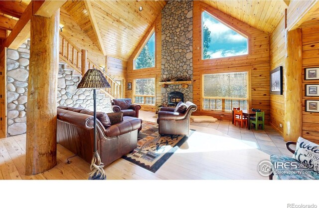 315 County Road 4454, Grand Lake, CO 80447 - living area featuring a stone fireplace, high vaulted ceiling, stairs, wooden ceiling, and wooden walls