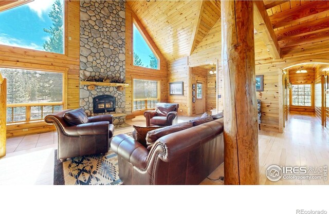 315 County Road 4454, Grand Lake, CO 80447 - living room with high vaulted ceiling, wooden walls, a stone fireplace, wooden ceiling, and beam ceiling