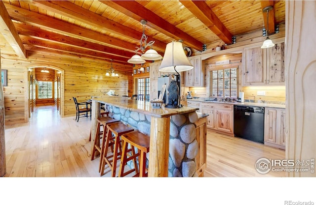 315 County Road 4454, Grand Lake, CO 80447 - kitchen featuring black dishwasher, light wood-style floors, wood walls, arched walkways, and a sink