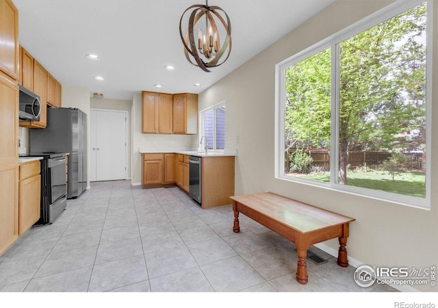 1724 Holeman Dr, Erie, CO 80516 - kitchen with stainless steel appliances, a chandelier, light countertops, plenty of natural light, and recessed lighting