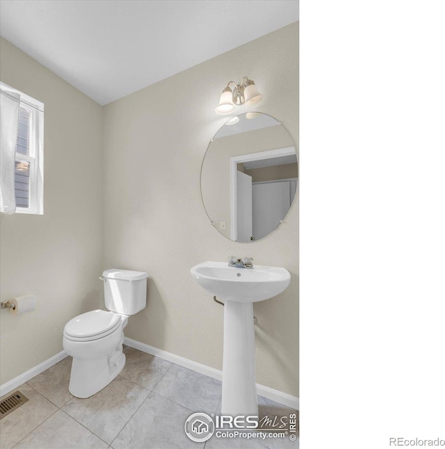 1724 Holeman Dr, Erie, CO 80516 - bathroom with toilet, tile patterned floors, baseboards, and a sink