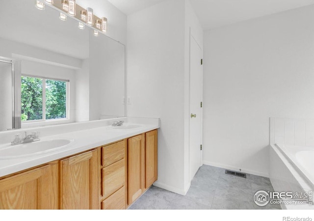 1724 Holeman Dr, Erie, CO 80516 - full bathroom featuring a bath, double vanity, baseboards, and tile patterned floors