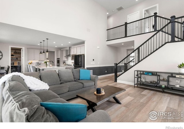 5085 Blanchette St, Timnath, CO 80547 - living room featuring light wood finished floors, a high ceiling, stairway, recessed lighting, and baseboards