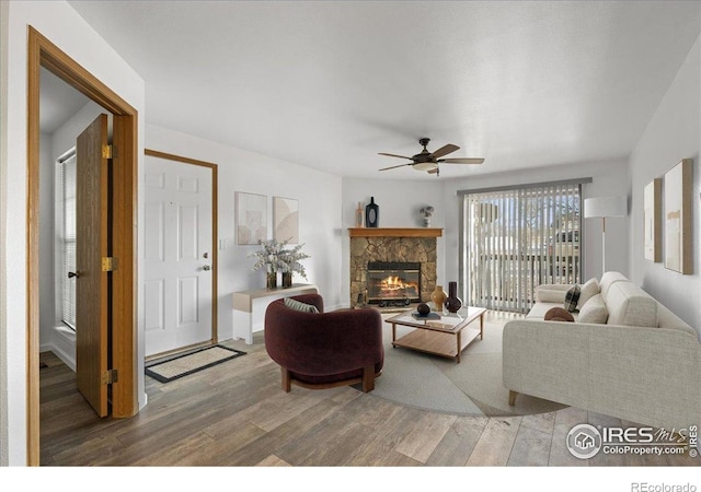 7820 W 87th Dr Unit K, Arvada, CO 80005 - living room featuring wood finished floors, a ceiling fan, and a stone fireplace