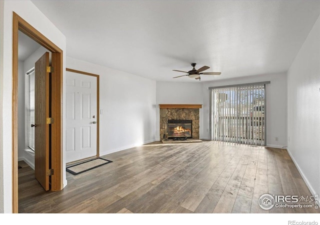7820 W 87th Dr Unit K, Arvada, CO 80005 - unfurnished living room with ceiling fan, wood finished floors, a fireplace, and baseboards