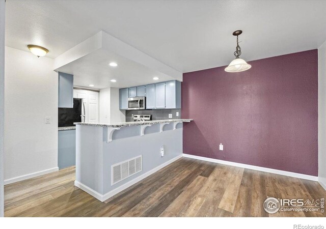 7820 W 87th Dr Unit K, Arvada, CO 80005 - kitchen featuring appliances with stainless steel finishes, dark wood-style flooring, a peninsula, baseboards, and recessed lighting