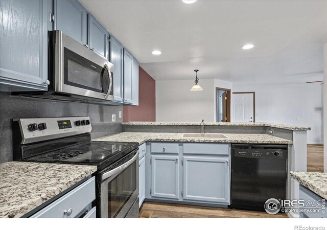 7820 W 87th Dr Unit K, Arvada, CO 80005 - kitchen with appliances with stainless steel finishes, a sink, a peninsula, light wood-style floors, and recessed lighting