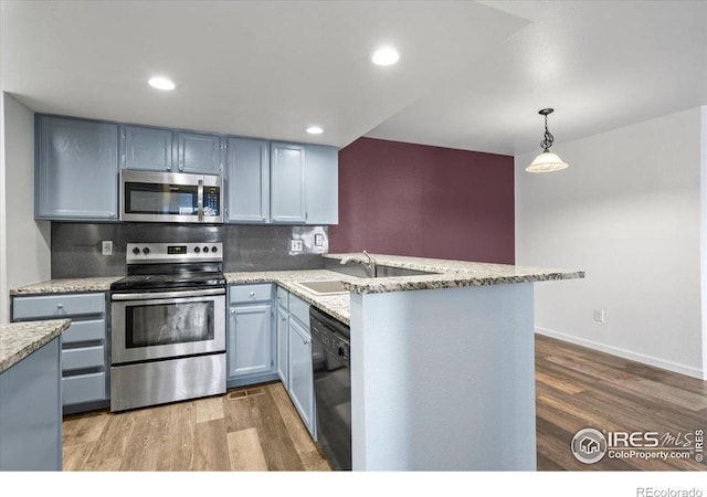 7820 W 87th Dr Unit K, Arvada, CO 80005 - kitchen with stainless steel appliances, wood finished floors, a sink, a peninsula, and recessed lighting
