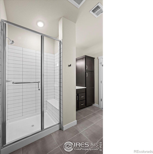 350 High Point Dr Unit 201, Longmont, CO 80504 - bathroom featuring tile patterned floors, a stall shower, and baseboards