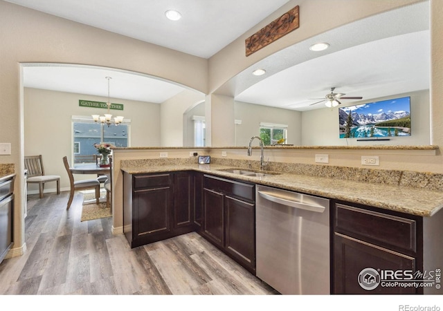 kitchen with dishwasher, a sink, dark brown cabinetry, arched walkways, and light wood-style floors