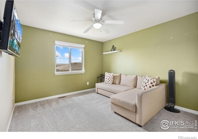 living room featuring carpet, a ceiling fan, and baseboards