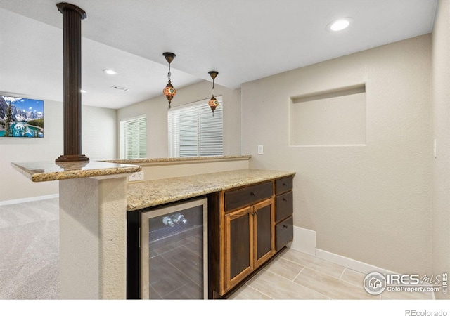 kitchen featuring beverage cooler, baseboards, hanging light fixtures, recessed lighting, and light stone counters
