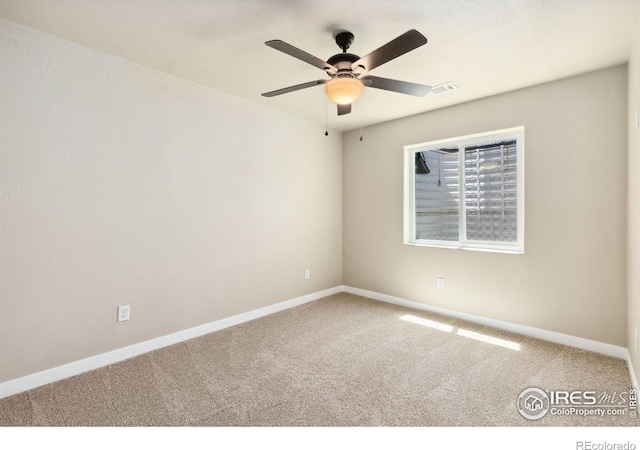 spare room with carpet floors, baseboards, and a ceiling fan