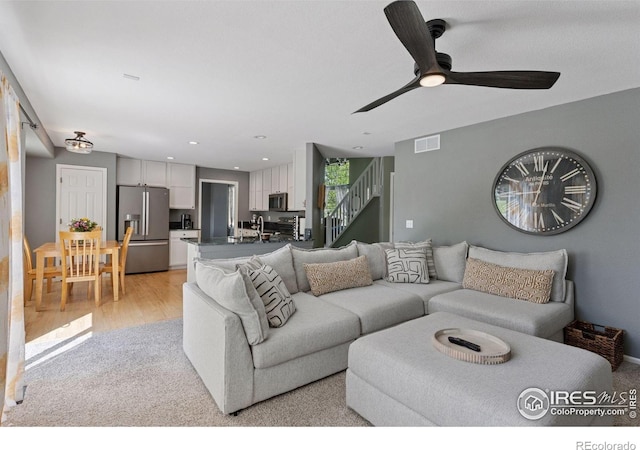 4416 Pika Dr, Loveland, CO 80537 - living room with light carpet, stairway, a ceiling fan, and recessed lighting