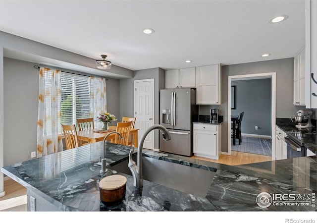 4416 Pika Dr, Loveland, CO 80537 - kitchen with stainless steel fridge, white cabinetry, baseboards, a sink, and recessed lighting
