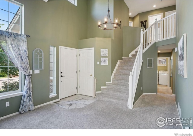 4416 Pika Dr, Loveland, CO 80537 - foyer entrance with carpet floors, a chandelier, a towering ceiling, washer / clothes dryer, and baseboards