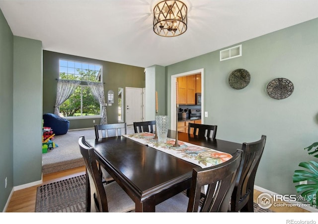 4416 Pika Dr, Loveland, CO 80537 - dining area featuring baseboards, a chandelier, and wood finished floors