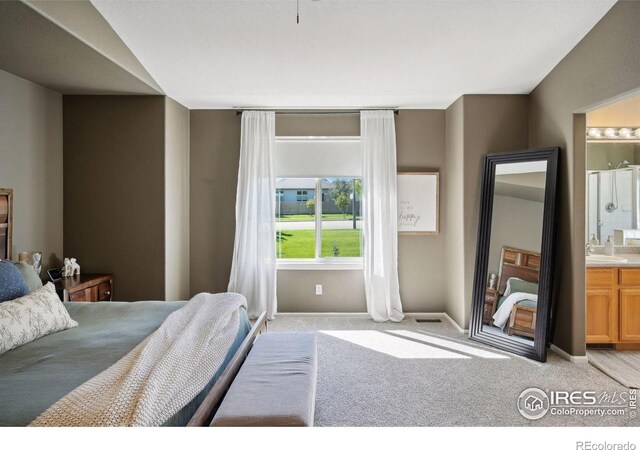 4416 Pika Dr, Loveland, CO 80537 - bedroom with light colored carpet, connected bathroom, baseboards, and a sink