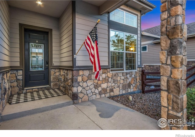 2119 Pelican Farm Rd, Windsor, CO 80550 - exterior entry at dusk featuring stone siding