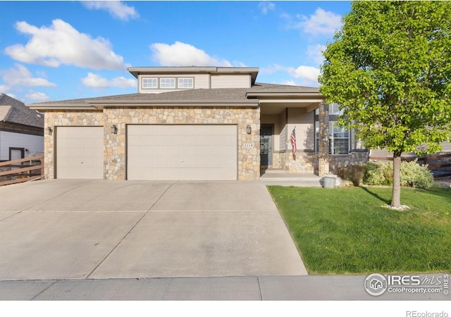 2119 Pelican Farm Rd, Windsor, CO 80550 - prairie-style house featuring stone siding, driveway, a garage, and a front lawn