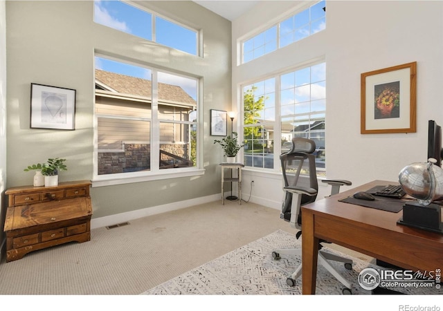 2119 Pelican Farm Rd, Windsor, CO 80550 - carpeted home office with baseboards and a towering ceiling
