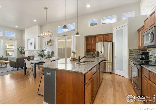 2119 Pelican Farm Rd, Windsor, CO 80550 - kitchen with stainless steel appliances, a sink, brown cabinets, light wood-style flooring, and recessed lighting
