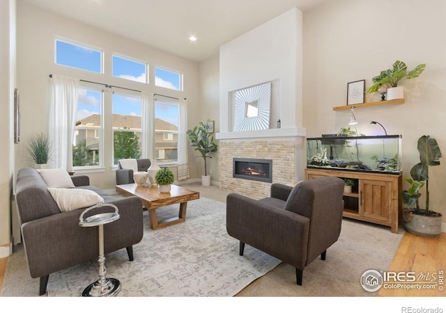 2119 Pelican Farm Rd, Windsor, CO 80550 - living room featuring a fireplace, a high ceiling, light wood-style floors, and recessed lighting