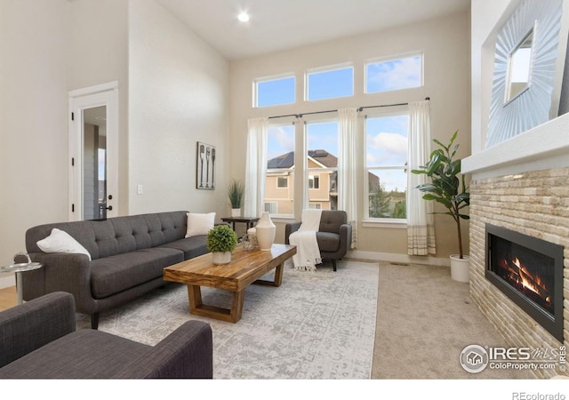 2119 Pelican Farm Rd, Windsor, CO 80550 - carpeted living area featuring a towering ceiling, healthy amount of natural light, a brick fireplace, baseboards, and recessed lighting