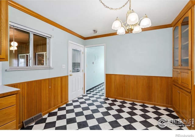 1320 Lory St, Fort Collins, CO 80524 - unfurnished dining area with dark flooring, a wainscoted wall, a chandelier, wood walls, and crown molding