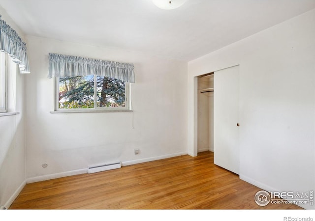1320 Lory St, Fort Collins, CO 80524 - unfurnished bedroom featuring baseboard heating, wood finished floors, baseboards, and a closet