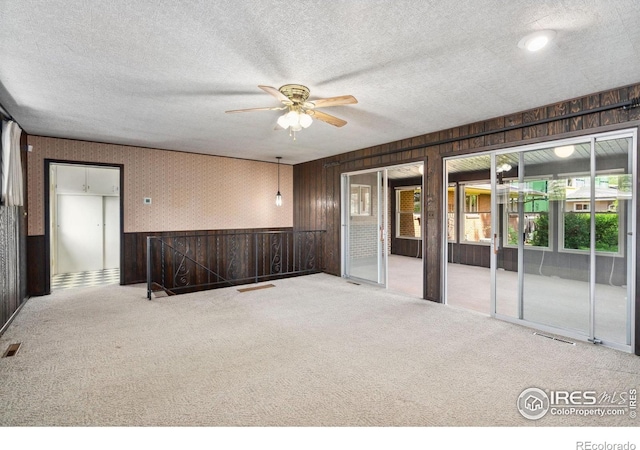1320 Lory St, Fort Collins, CO 80524 - carpeted empty room featuring ceiling fan, wooden walls, a textured ceiling, and wainscoting