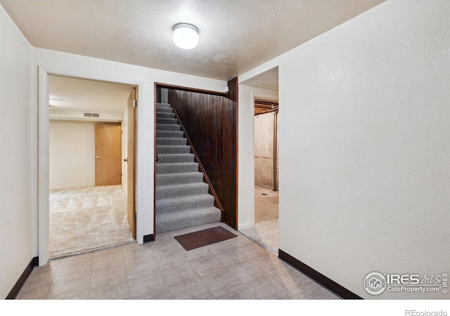 1320 Lory St, Fort Collins, CO 80524 - stairway featuring tile patterned floors, baseboards, a textured ceiling, and carpet floors