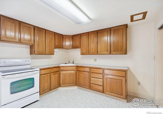 1320 Lory St, Fort Collins, CO 80524 - kitchen with white range with electric stovetop, brown cabinetry, light countertops, and a sink