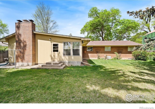 1320 Lory St, Fort Collins, CO 80524 - rear view of property featuring a lawn and a chimney