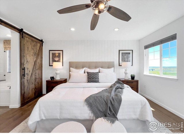 6506 Merrimack Dr, Castle Pines, CO 80108 - bedroom with wood finished floors, a barn door, baseboards, recessed lighting, and ceiling fan