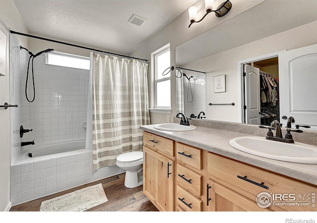 711 Mt Evans Ave, Severance, CO 80550 - full bath with wood finished floors, healthy amount of natural light, toilet, double vanity, and a textured ceiling
