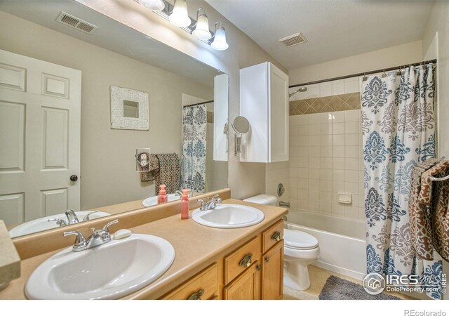bathroom with toilet, double vanity, shower / bath combination with curtain, and tile patterned flooring