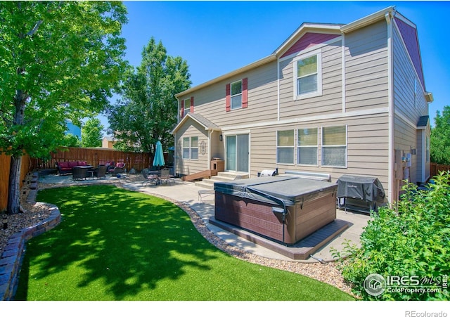 back of property featuring a hot tub, a patio, and an outdoor living space
