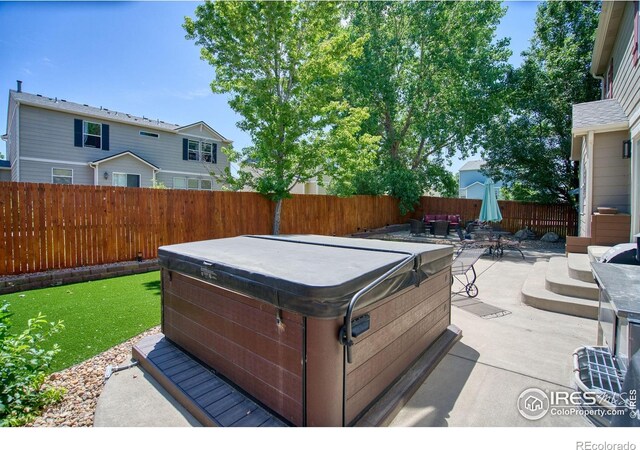 view of patio / terrace featuring a hot tub, a fenced backyard, and outdoor dining area