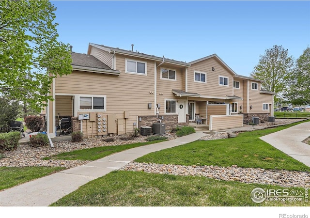 rear view of house with a yard and central air condition unit
