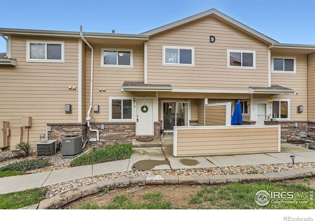 view of property featuring central AC and brick siding