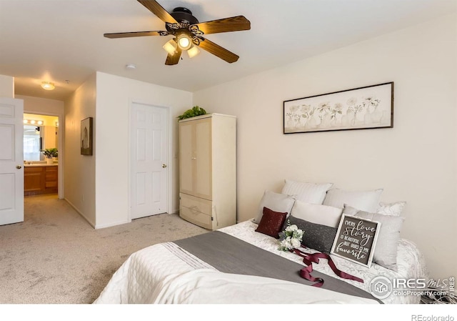 carpeted bedroom with baseboards, ensuite bathroom, and ceiling fan