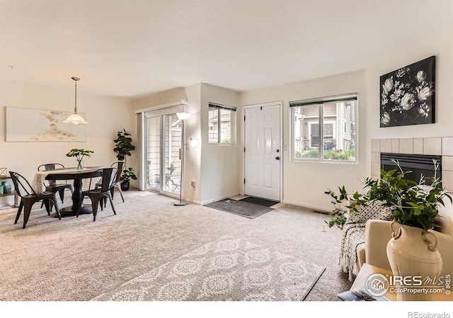 carpeted foyer with baseboards and a fireplace