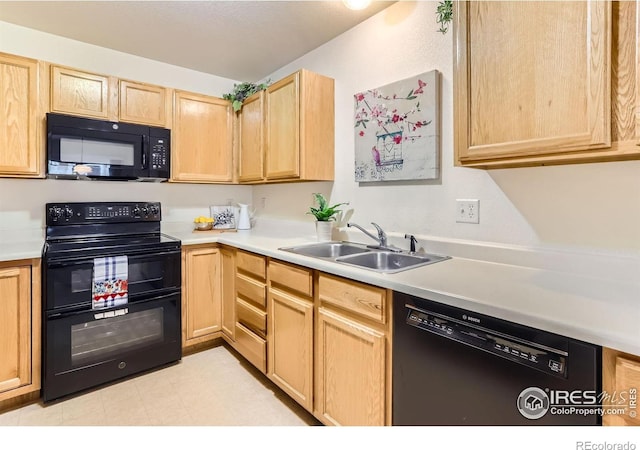kitchen with black appliances, a sink, light brown cabinets, and light countertops
