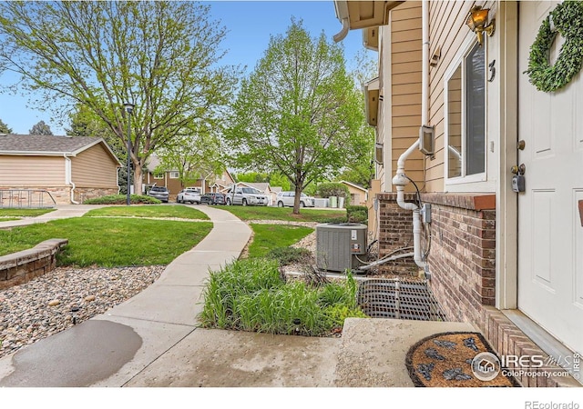 view of yard featuring central AC unit and a residential view