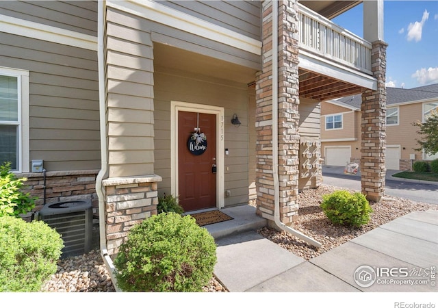 doorway to property with a balcony and cooling unit